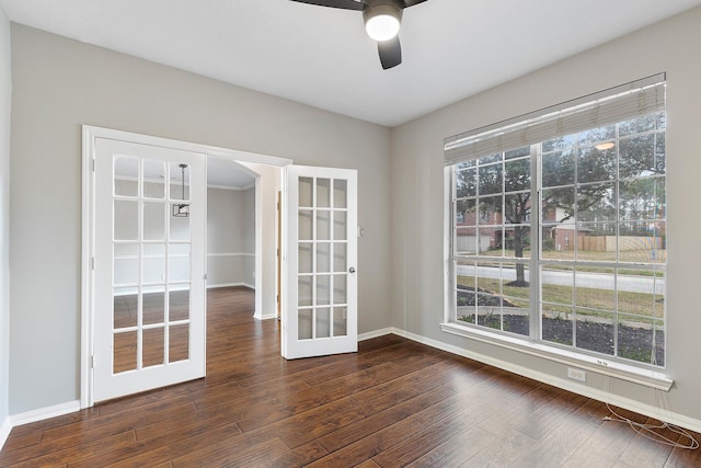 empty room featuring baseboards, dark wood finished floors, a ceiling fan, and french doors