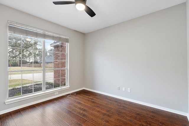 spare room featuring ceiling fan, baseboards, and dark wood finished floors