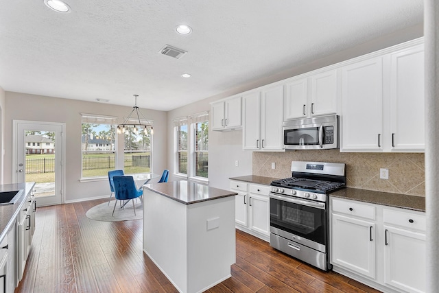 kitchen featuring pendant lighting, stainless steel appliances, and white cabinets