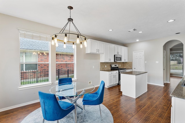 dining room featuring a healthy amount of sunlight and dark hardwood / wood-style floors