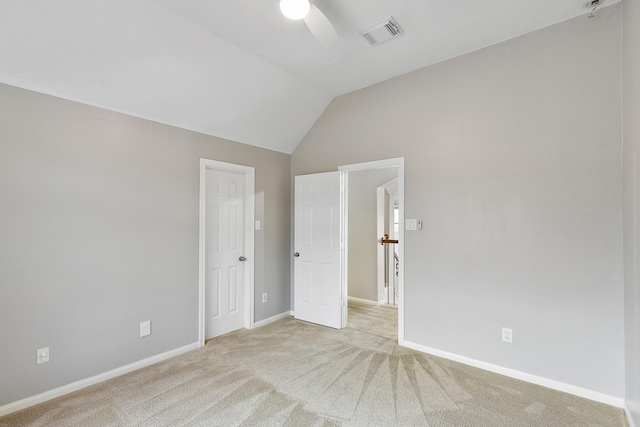 unfurnished bedroom featuring light carpet, lofted ceiling, and ceiling fan