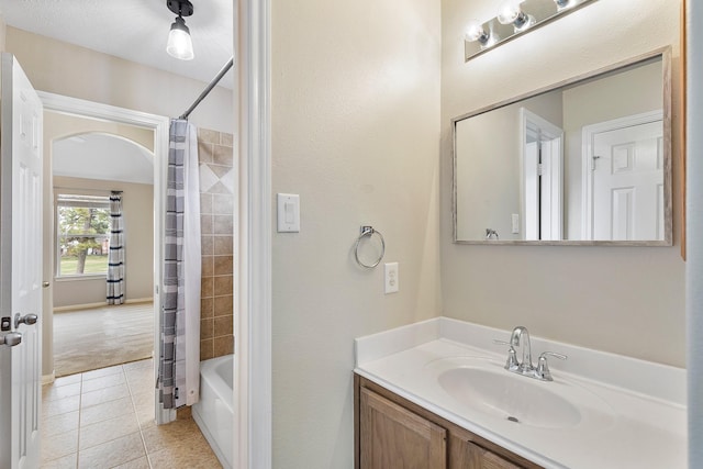 bathroom with tile patterned flooring, shower / bathtub combination with curtain, and vanity