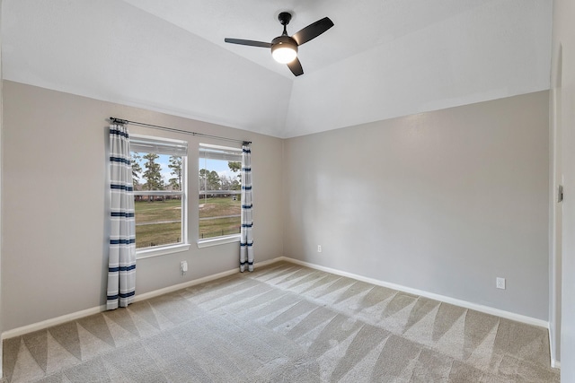 carpeted empty room featuring lofted ceiling, a ceiling fan, and baseboards