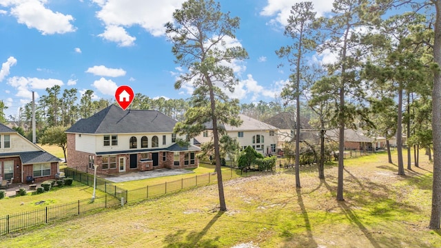 back of property featuring a yard, brick siding, and a fenced backyard