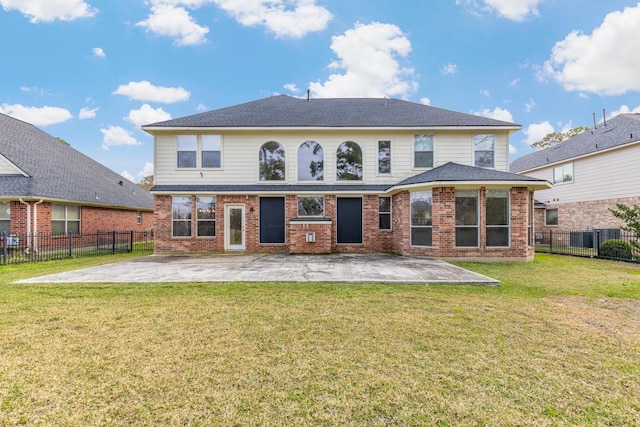 back of house featuring a yard, a patio, brick siding, and a fenced backyard