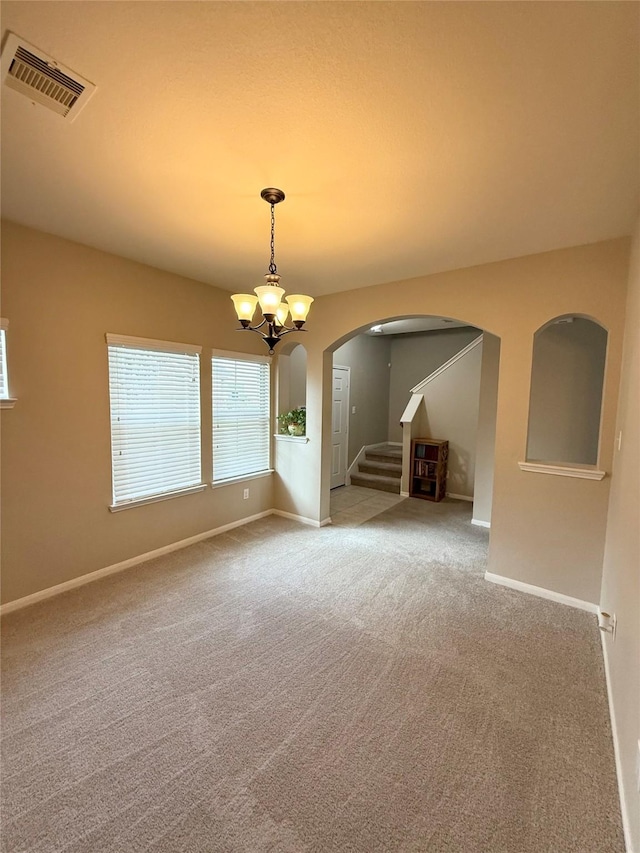 unfurnished living room featuring an inviting chandelier and carpet floors