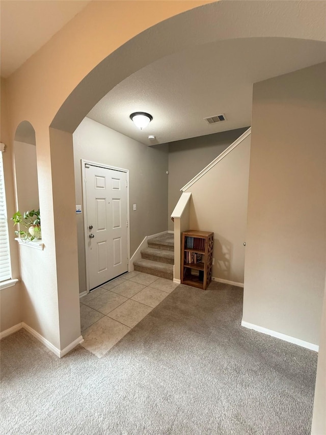 entryway with carpet flooring and a textured ceiling