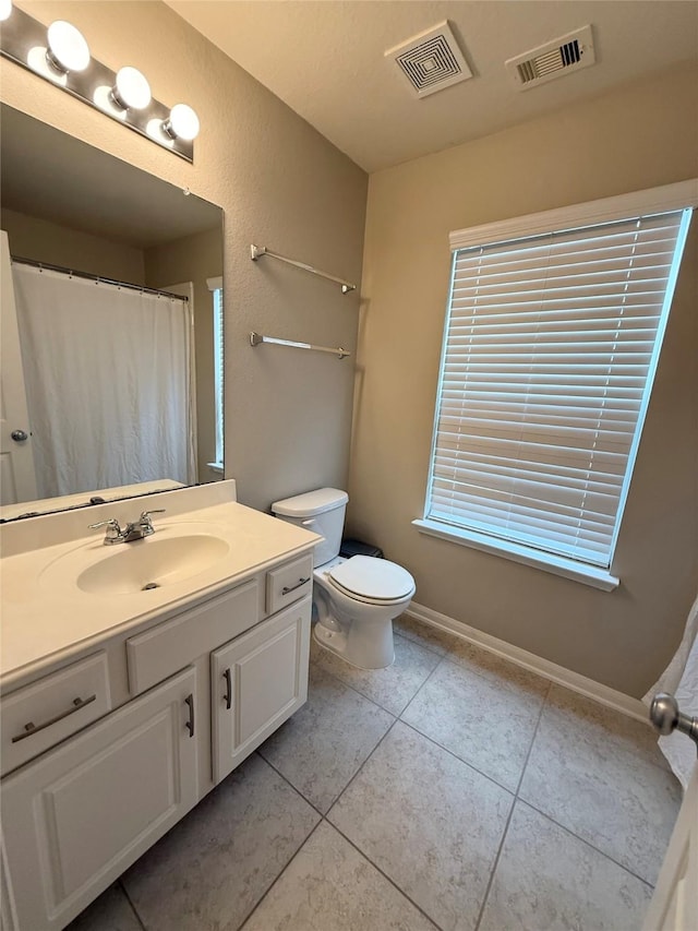 bathroom featuring vanity, tile patterned floors, and toilet