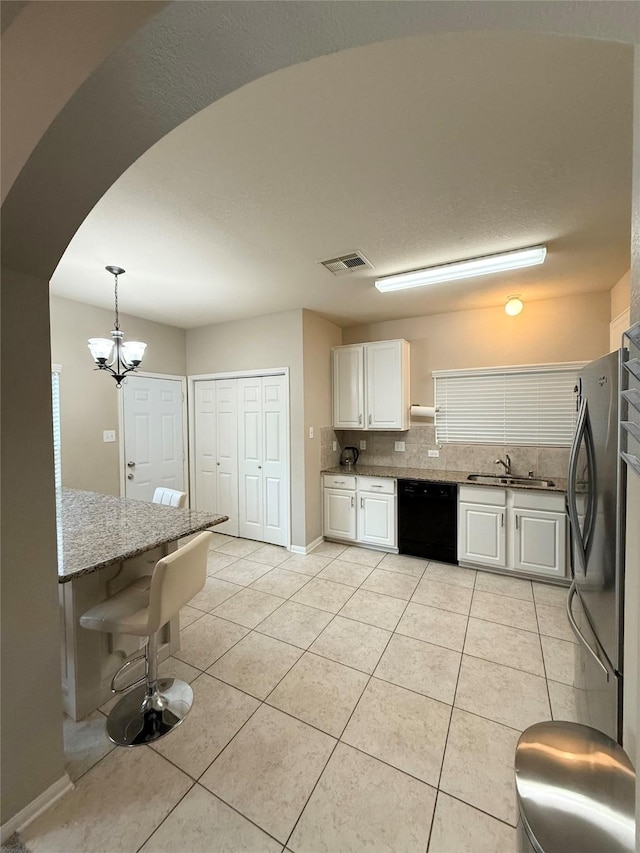 kitchen with white cabinetry, decorative light fixtures, light tile patterned floors, stainless steel refrigerator, and black dishwasher