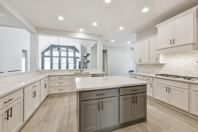 kitchen featuring gray cabinets, tasteful backsplash, sink, white cabinets, and stainless steel gas cooktop