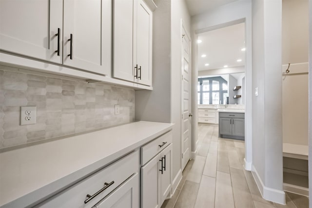 bar featuring white cabinetry and backsplash