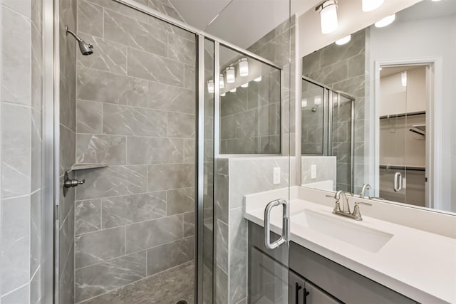 bathroom with vanity and a shower with door