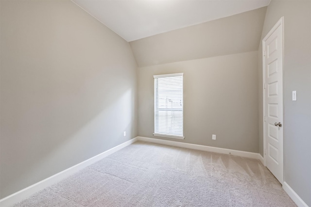 carpeted spare room featuring lofted ceiling