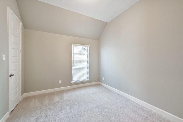 unfurnished room featuring light colored carpet and lofted ceiling