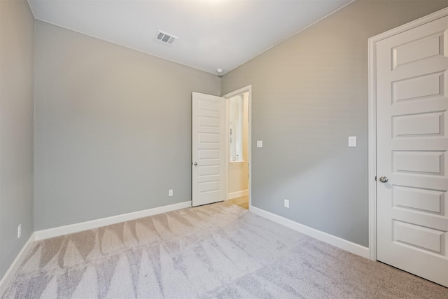 unfurnished room featuring light colored carpet