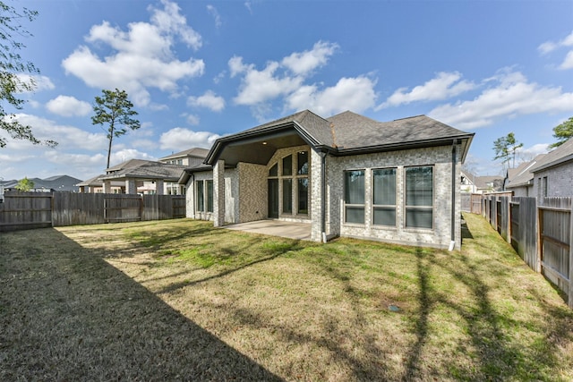 back of house featuring a patio area and a lawn