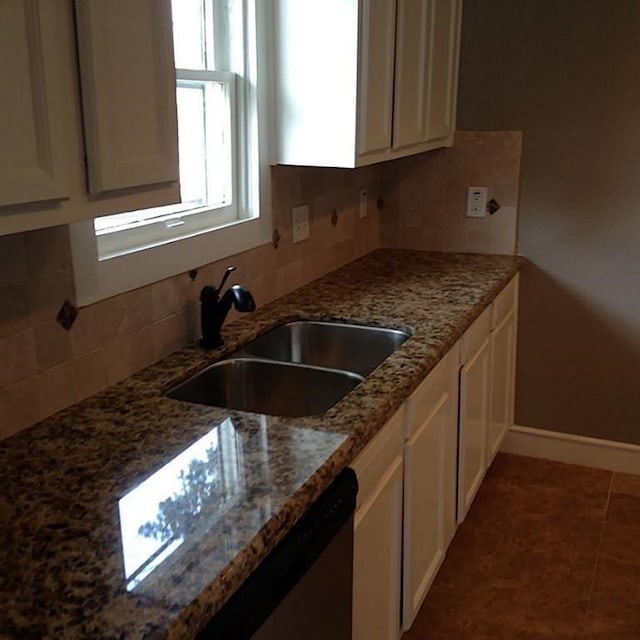 kitchen with white cabinetry, sink, decorative backsplash, and stone counters