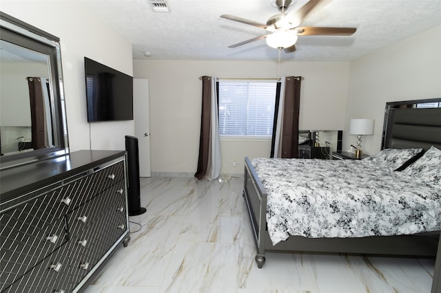 bedroom with ceiling fan and a textured ceiling