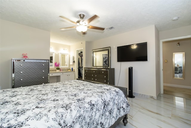 bedroom featuring visible vents, marble finish floor, a textured ceiling, connected bathroom, and baseboards