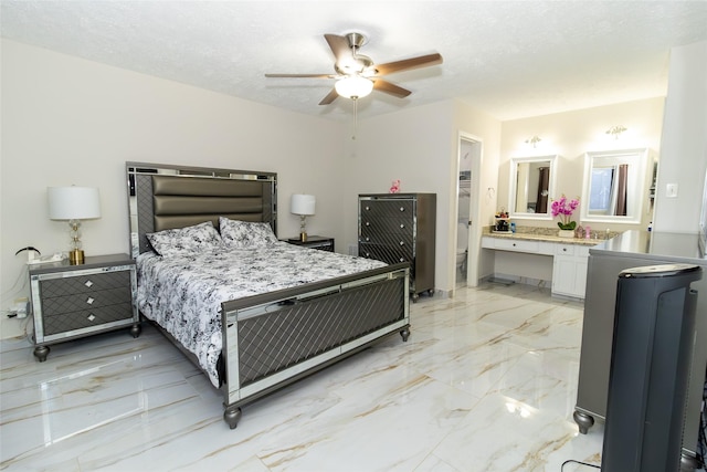 bedroom with marble finish floor, a textured ceiling, ensuite bathroom, and ceiling fan