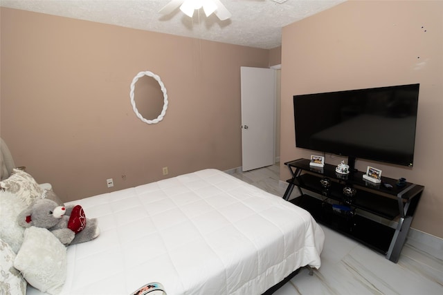 bedroom with ceiling fan and a textured ceiling