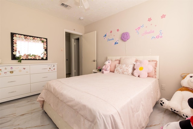 bedroom with ceiling fan and a textured ceiling