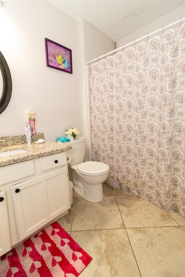 bathroom with vanity, a textured ceiling, curtained shower, tile patterned floors, and toilet