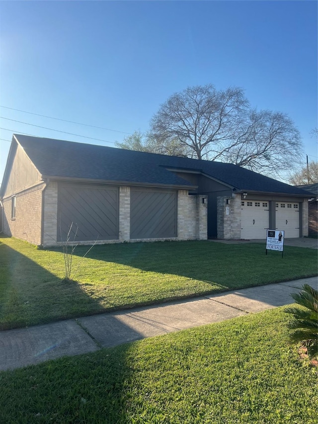 view of front of house featuring a lawn, a garage, and driveway