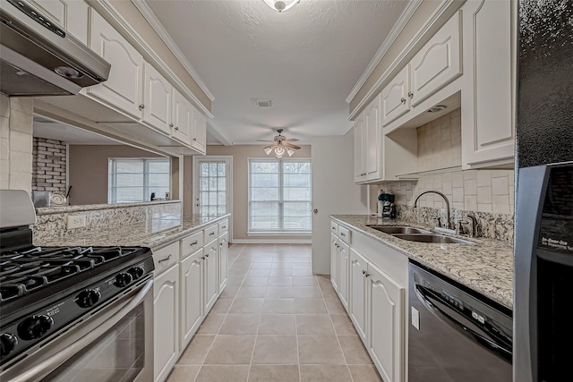 kitchen featuring dishwasher, sink, white cabinets, light stone counters, and stainless steel range with gas stovetop