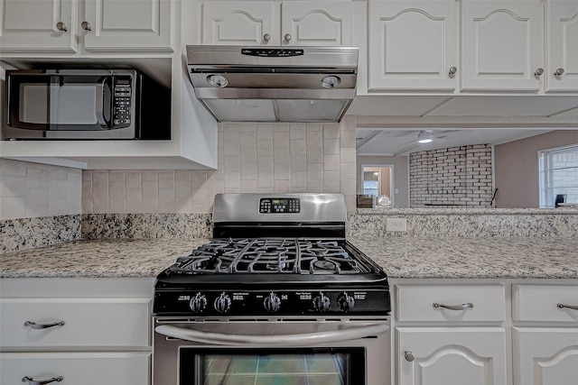 kitchen with ventilation hood, gas stove, white cabinets, and decorative backsplash