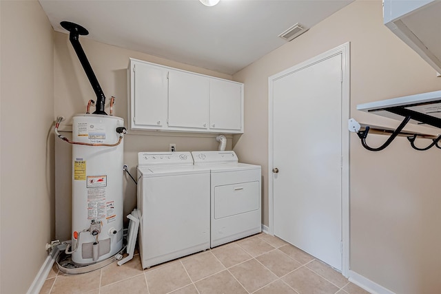 clothes washing area featuring cabinets, light tile patterned floors, washing machine and dryer, and gas water heater