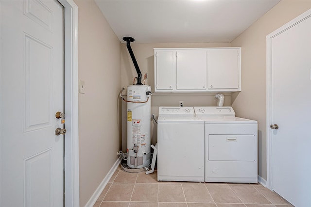 washroom with cabinets, washing machine and clothes dryer, light tile patterned floors, and gas water heater