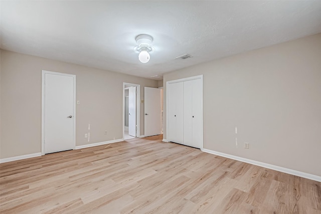 unfurnished bedroom featuring light hardwood / wood-style flooring and ensuite bathroom