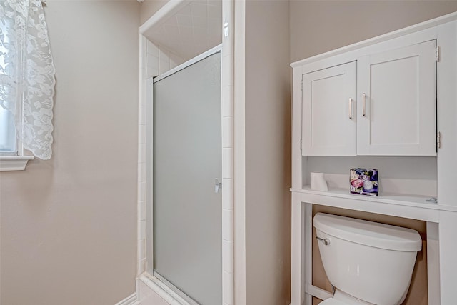 bathroom with toilet and an enclosed shower