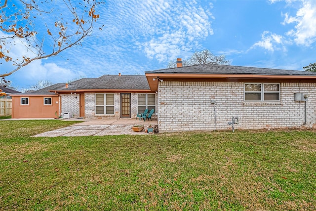 back of property featuring a patio and a yard