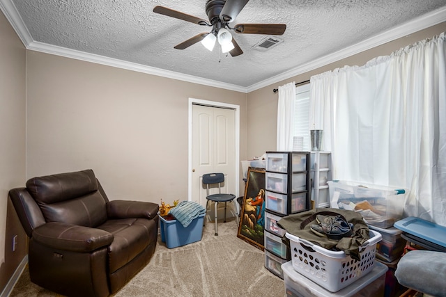 sitting room with crown molding, ceiling fan, carpet, and a textured ceiling