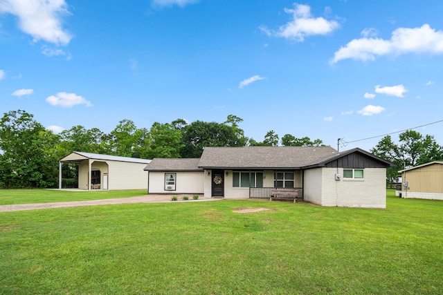 ranch-style home featuring a front lawn, a carport, and covered porch