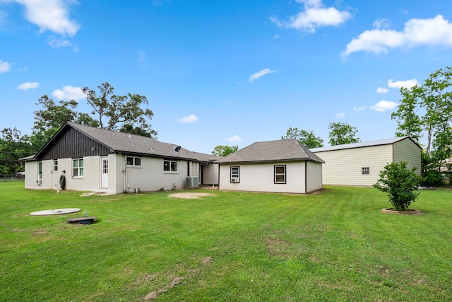 back of house with central AC and a lawn