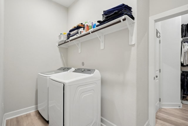 washroom with separate washer and dryer and light hardwood / wood-style flooring