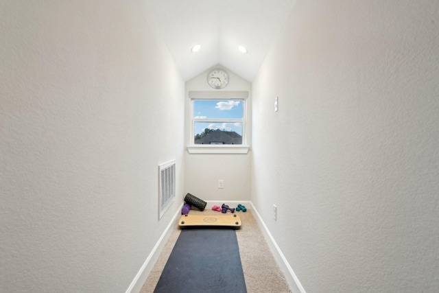 corridor featuring lofted ceiling and carpet