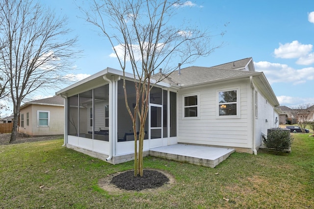 rear view of property with a patio area, a sunroom, and a lawn