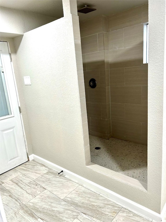 231 Dehart St Unit Cr653, Liverpool, TX 77577 - bathroom with tiled shower, baseboards, and a textured wall