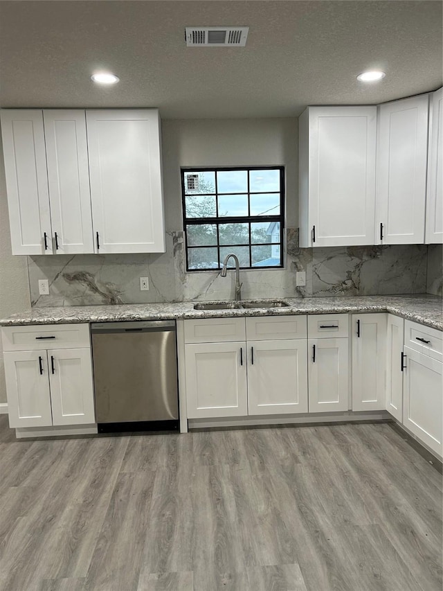 231 Dehart St Unit Cr653, Liverpool, TX 77577 - kitchen with dishwasher, a sink, light wood-type flooring, white cabinets, and a textured ceiling
