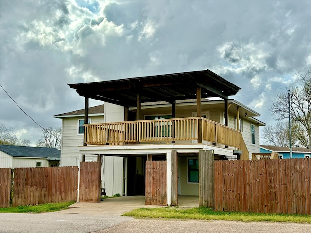 231 Dehart St Unit Cr653, Liverpool, TX 77577 - back of house with concrete driveway, fence, a carport, and a balcony