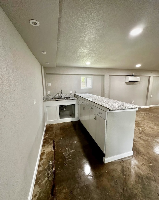 231 Dehart St Unit Cr653, Liverpool, TX 77577 - kitchen with concrete floors, baseboards, a textured ceiling, a wall mounted AC, and a peninsula