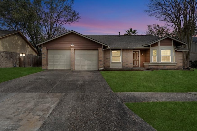 single story home with a garage and a lawn