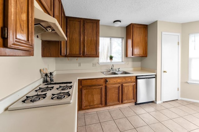 kitchen featuring sink, light tile patterned floors, a textured ceiling, and dishwasher