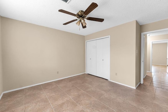 unfurnished bedroom featuring ceiling fan, a textured ceiling, and a closet