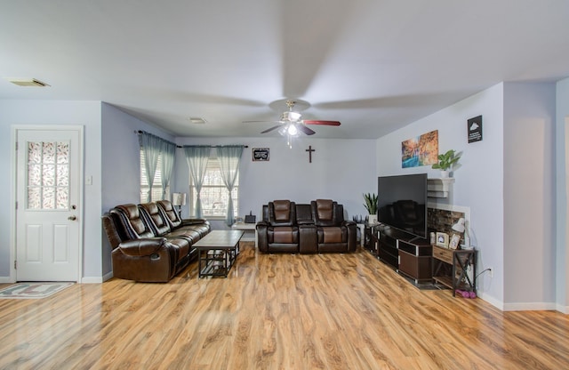 living room with ceiling fan and light wood-type flooring