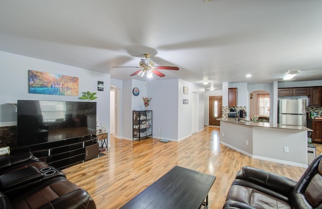 living room with ceiling fan and light hardwood / wood-style floors